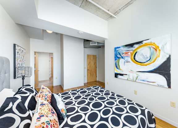 A bedroom with a bed and a painting on the wall.