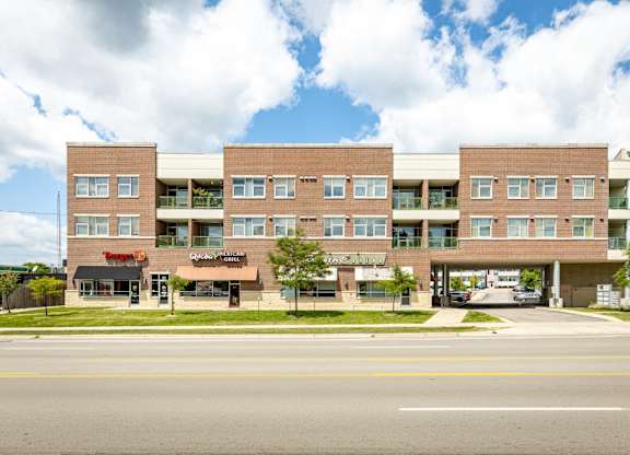 A large brick building with a white roof and a sign that says