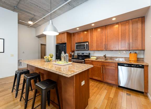 A kitchen with wooden cabinets and a marble countertop.