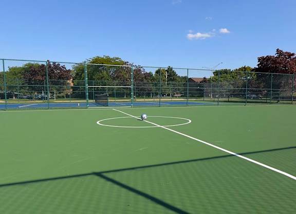 A tennis court with a net and a player in the middle.
