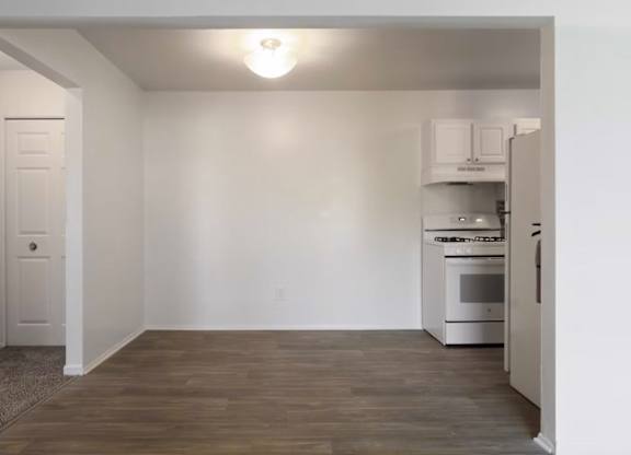A kitchen with white cabinets and a white oven.