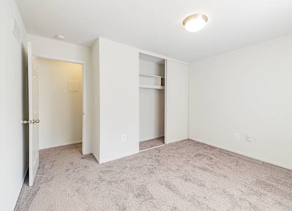 A room with a carpeted floor and a white door.