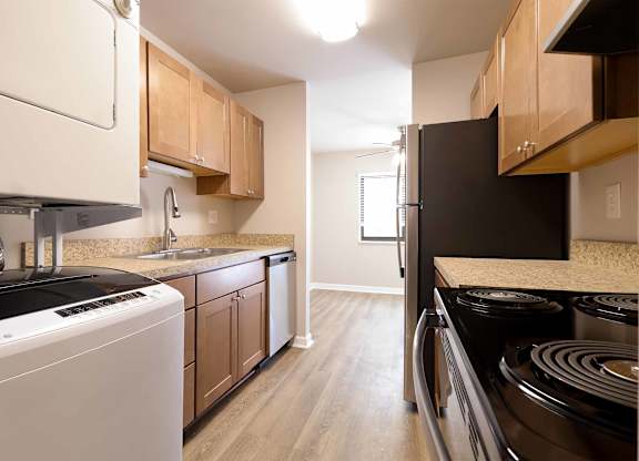 A kitchen with a black stove top oven and white appliances.