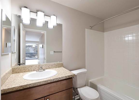 A bathroom with a sink, toilet, and bathtub.