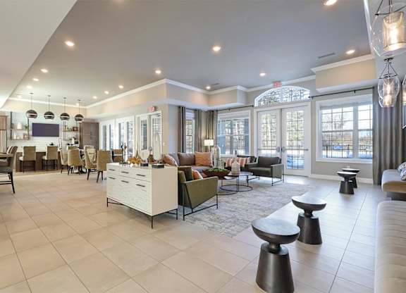 A spacious living room with a kitchen area in the background.