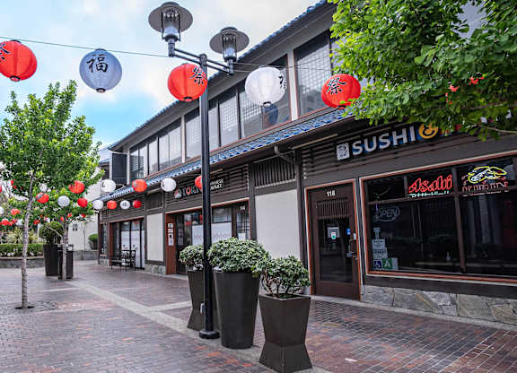 A street with red lanterns hanging from the ceiling.