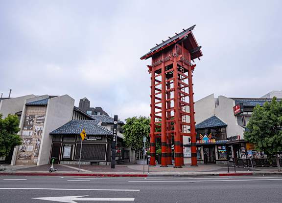 A red pagoda-style tower stands in the middle of a street.