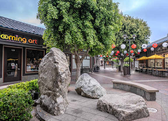 A street view of a shopping area with a cafe named "Blooming Art".