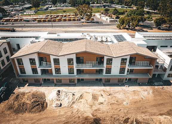 A large building with a brown roof is under construction.