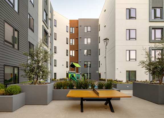 A modern courtyard with a bench and a playground.