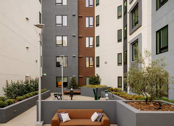 A courtyard with a couch and a table surrounded by buildings.