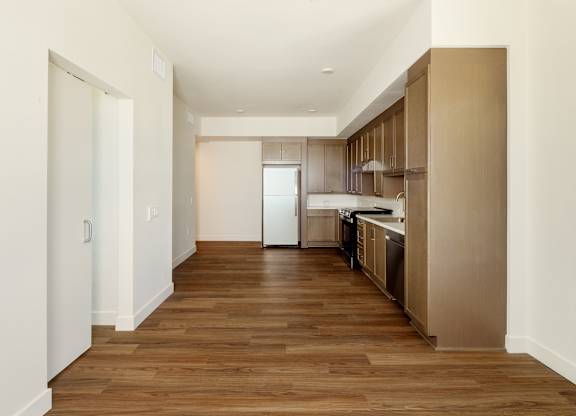 A long hallway with a kitchen at the end.