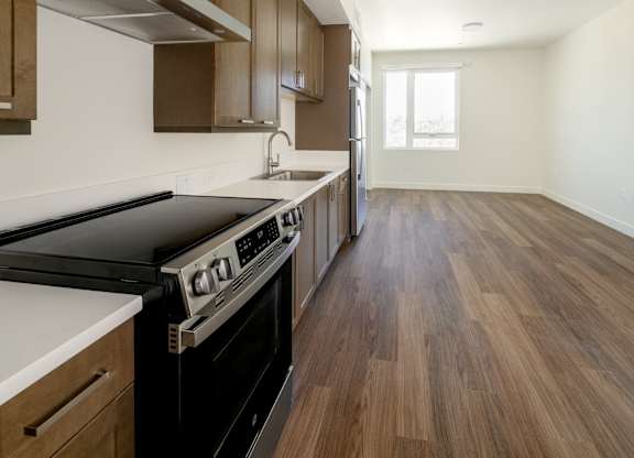 A kitchen with wooden cabinets and a black stove top oven.
