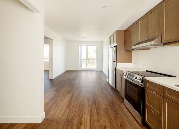 A kitchen with wooden floors and white walls.