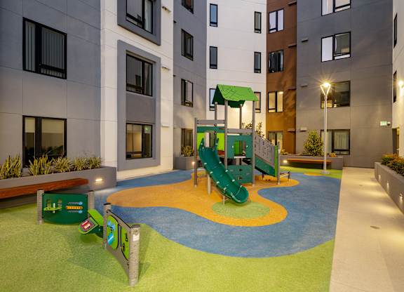 A playground area with a slide and a green canopy.