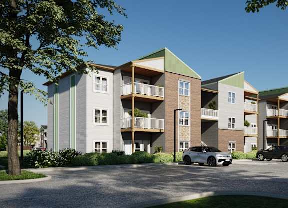 A modern apartment complex with cars parked in front.