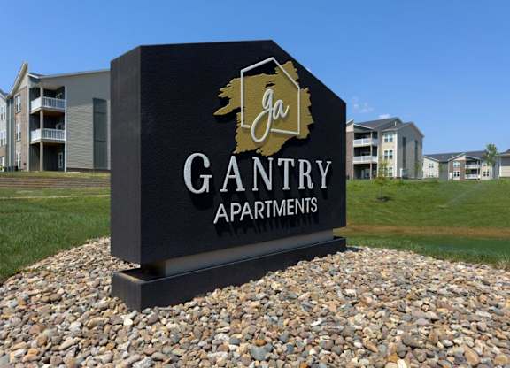 A sign for Gantry Apartments in front of apartment buildings.
