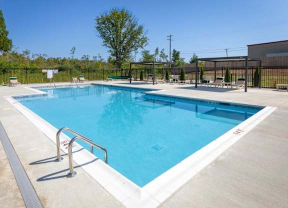A large outdoor swimming pool with a metal railing.