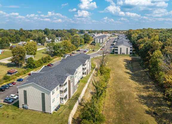 A large apartment complex with a parking lot in front.