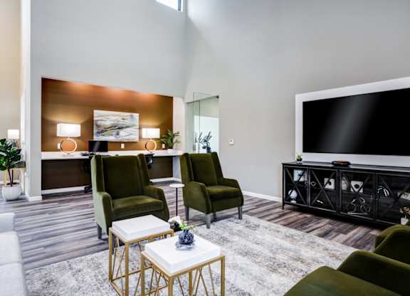 A living room with a large flat screen TV and a coffee table.