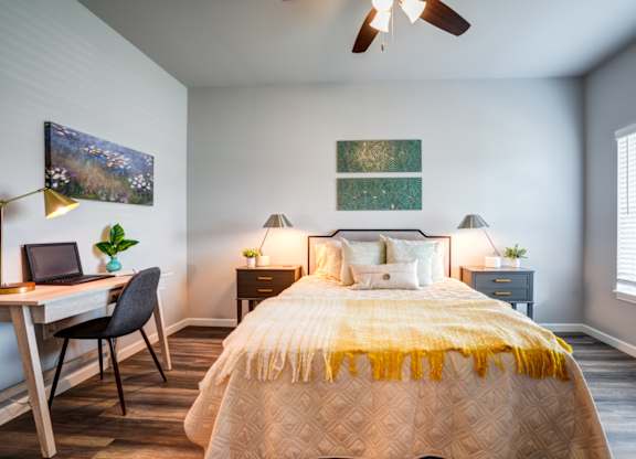 A bedroom with a bed, desk, and chair.