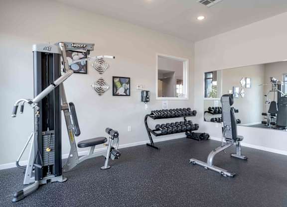 A spacious home gym with a variety of equipment including a treadmill, weights, and exercise machines.