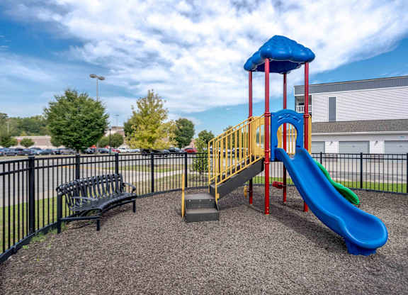 A playground with a blue slide and a yellow and red structure.