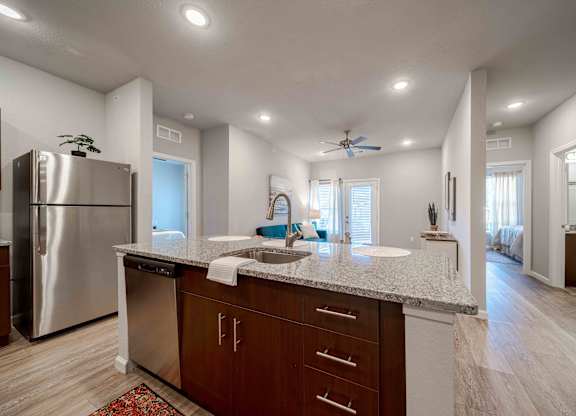 a kitchen with a granite counter top and a stainless steel refrigerator