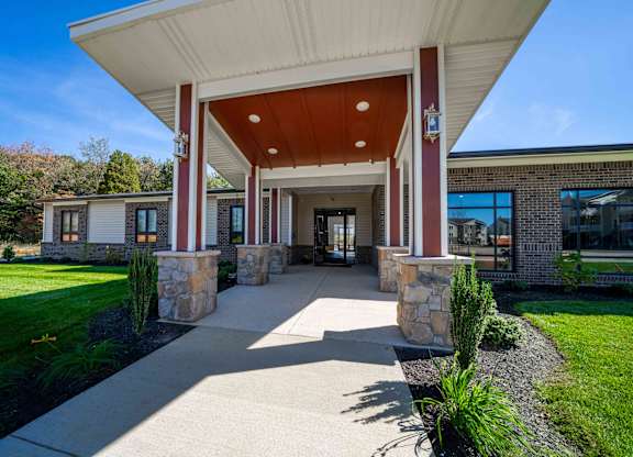 a covered walkway in front of a brick building with columns