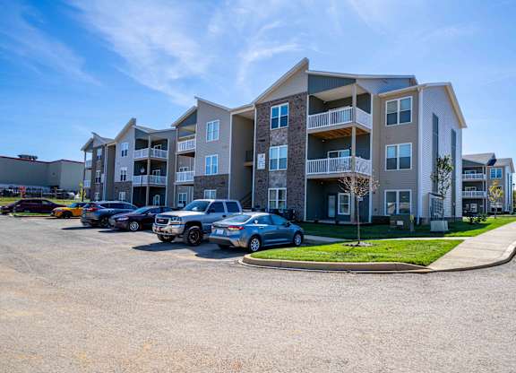 an apartment building with cars parked in front of it
