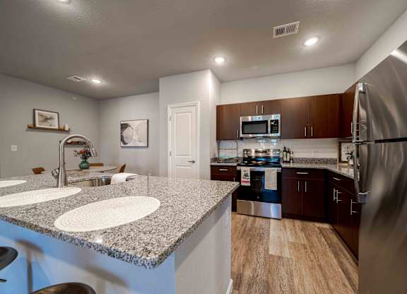 a kitchen with stainless steel appliances and granite counter tops