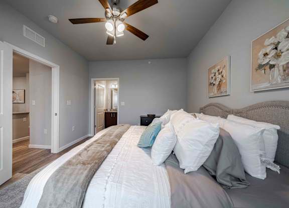 a bedroom with a large bed and a ceiling fan