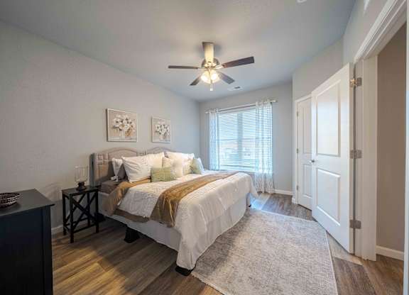 a bedroom with a ceiling fan and a bed