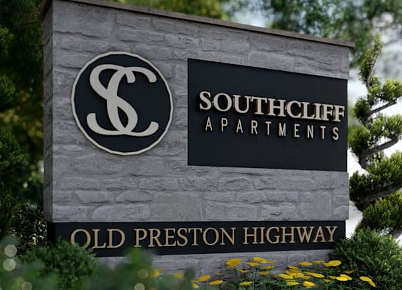 A sign for Southcliff Apartments is displayed in front of some trees.