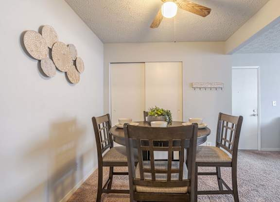 A dining room with a table and chairs.