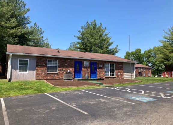 a brick building with blue doors in a parking lot