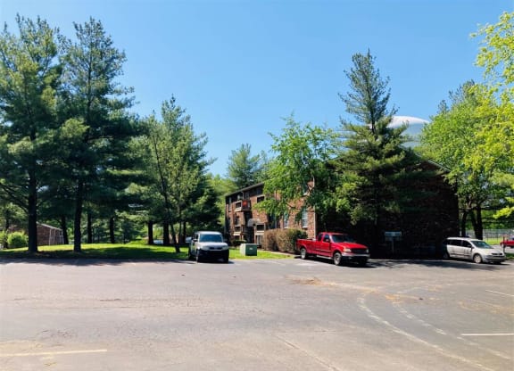 a parking lot with cars in front of a house