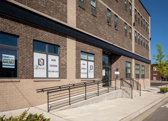 the front of a brick building with a ramp and stairs