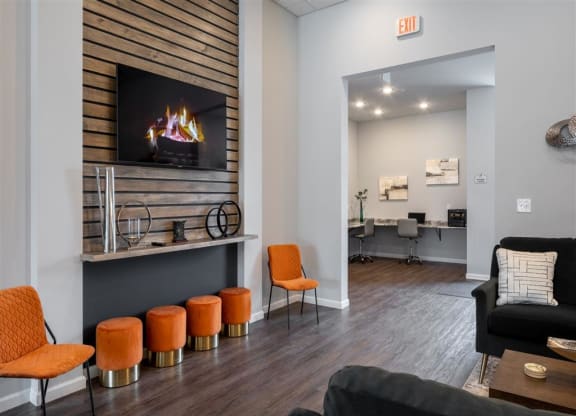 a living room with a fireplace and orange stools
