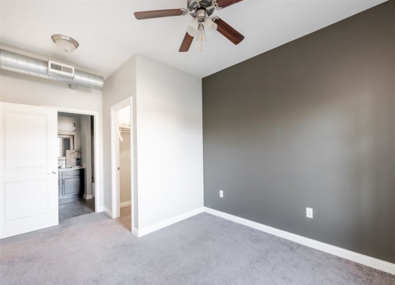 an empty living room with a ceiling fan