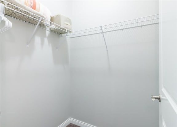 a walk in closet with white walls and a white closet door