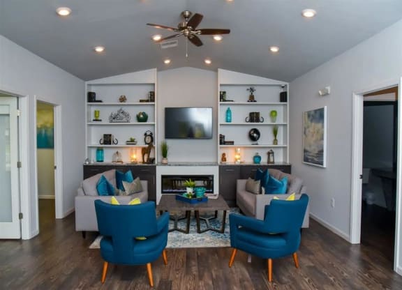 a living room with a couch and chairs and a tv