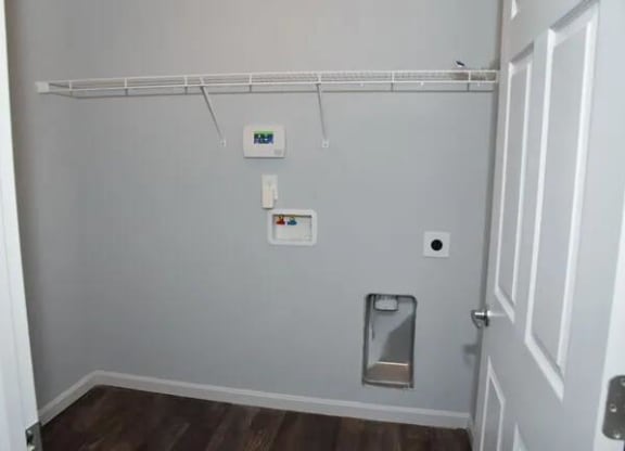 a bathroom with a toilet and a white wall