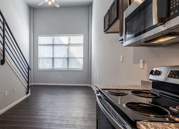 A kitchen with a stove top oven and microwave above it.