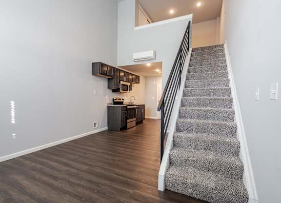 A staircase with a carpeted runner leads up to a second floor landing.