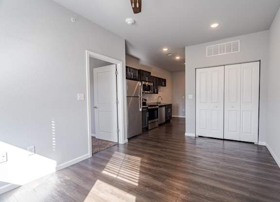 A kitchen with white cabinets and a wooden floor.