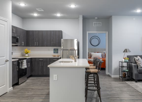 a kitchen and living room with a white counter top and