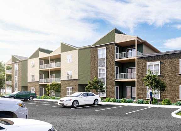 A modern apartment building with cars parked in front.