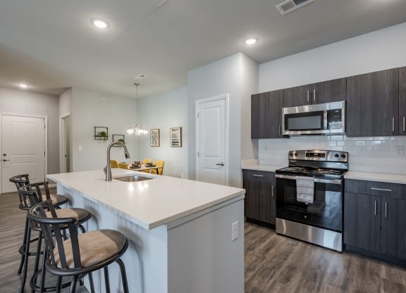 an open kitchen with a large island with stools