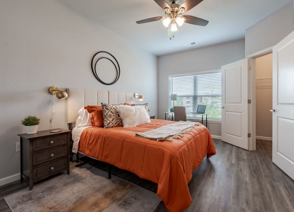 a bedroom with an orange bed and a ceiling fan